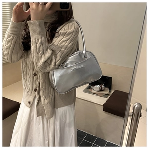 Detail of silver metallic PU tote bag featuring a decorative bow and mirror reflection