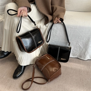 Retro shoulder bag in glossy leather with contrast stitching for stylish commuting