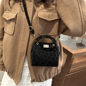 Mini sac seau imprimé léopard avec fermoir doré dans une scène de style de vie hivernal