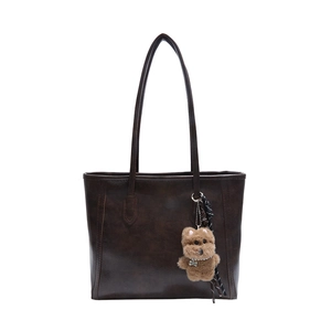 Retro dark brown large capacity tote bag with puppy pendant in a professional front view