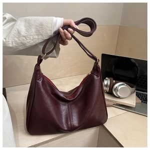 Detail of burgundy PU leather hobo bag with gold zipper and adjustable strap