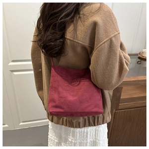 Close-up of burgundy suede bucket bag with fashion and classic text engraving