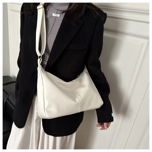 Detail of white PU leather shoulder bag with fine texture and gold buckle adjustment