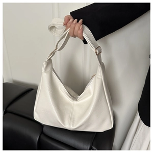 Detail of white PU leather crescent shoulder bag with golden zipper and wide strap