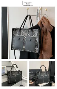Detail view of large leopard print tote bag with black leather trim and front buckle pockets