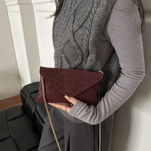 Borsa a bustina bordeaux con trama leopardata e tracolla a catena dorata