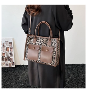 Detail of leopard print tote bag with brown leather trim and stylish front flap pockets