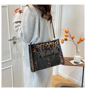 Detail of leopard print tote bag with dual front pockets and adjustable black shoulder strap
