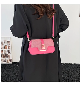 Detailed back view of a magenta chain crossbody bag on a model wearing black coat