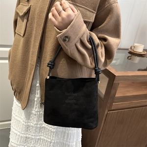 Fashionable black suede bucket bag with knotted shoulder strap and classic printed logo