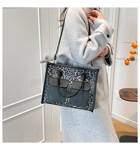 Detail of leopard print tote bag featuring dual front pockets and adjustable shoulder strap
