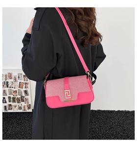 Detail view of a pink patchwork chain shoulder bag with a gold Greek Key metal buckle