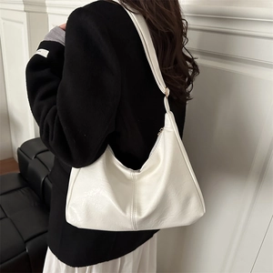 Minimalist creamy white faux leather hobo shoulder bag shown on a model side profile