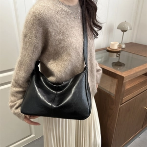 Minimalist black crescent hobo shoulder bag with vertical stitching for women