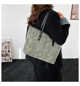 Détail du cabas matelassé vert sauge avec surpiqûres en losange et bride en cuir