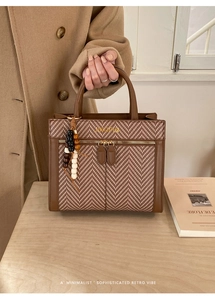 Detail of retro leather stitching and wood bead charm on the Jinopin tote bag