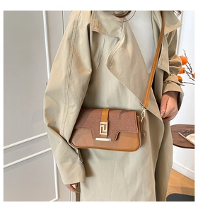 Detail of minimalist saddle bag showing brown twill fabric and faux leather patchwork