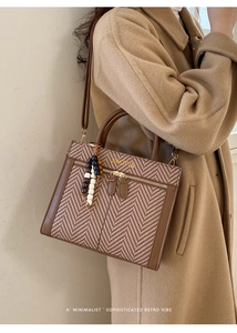 Detail of retro plaid stitching handbag with beaded tassel and golden hardware accents