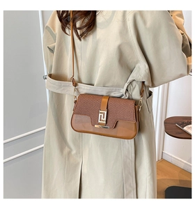 Detail of retro brown patchwork crossbody bag with textured weaving and golden metal buckle