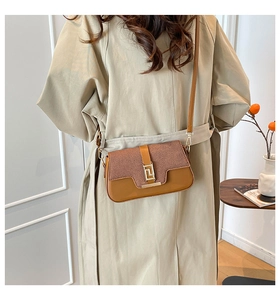 Detail of the golden geometric buckle on the brown patchwork crossbody square bag