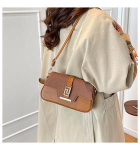 Detail of vintage brown shoulder bag with leather and woven texture and metal clasp