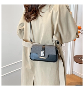 Detail of elegant two-tone crossbody bag with gray fabric and black leather contrast