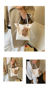 Détail du sac seau en cuir verni blanc avec bandoulière chaîne et charme d'ours