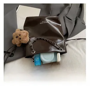Capacité intérieure d'un sac seau marron foncé avec bandoulière chaîne et ours