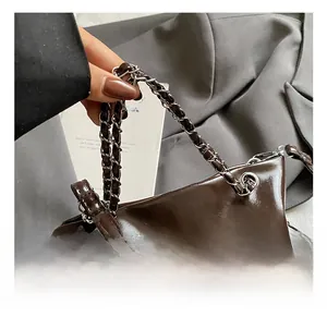 Détail du sac seau en cuir PU marron foncé brillant avec poignée en chaîne tissée