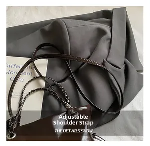 Détail macro d'un sac à main marron brillant avec bandoulière réglable et sangle en chaîne