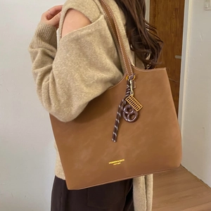 Retro brown leather tote bag with large capacity and decorative charm for daily wear