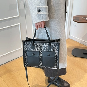 Leopard print tote bag with black front pockets and adjustable shoulder strap for women