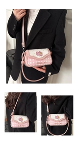 Detail view of pink and white crossbody bag with polka dots, bows, and heart patch
