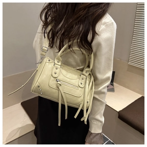 Detailed back view of a cream yellow Boston bag featuring fringe zippers and rivets