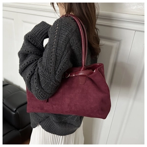 Burgundy suede tote bag worn by model with autumn knitwear for a chic commute style
