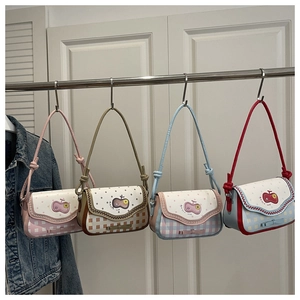 Detail view of plaid shoulder bags in pink brown blue and red with apple patches