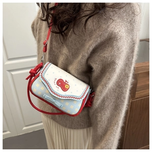 Detail of cute apple embroidery and blue bow on contrast plaid crossbody bag