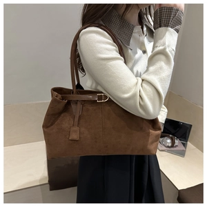Brown suede tote bag side view with leather strap and golden metal buckle details