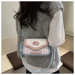 Detailed view of pink plaid crossbody bag with leather bow and cherry embroidery