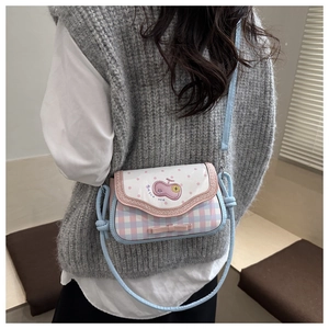 Detail of sweet plaid crossbody bag with cherry embroidery and pink bow decoration