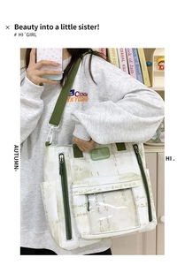 Detail of white canvas crossbody bag with green calligraphy and transparent pocket