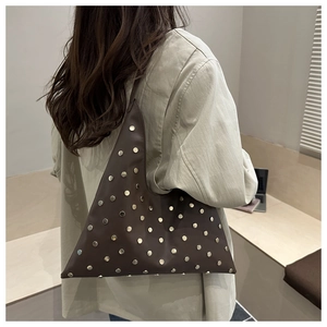 Détail du sac à bandoulière triangulaire marron foncé avec rivets argentés stylés