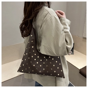 Détail du sac Hobo en cuir marron foncé avec rivets argentés sur la bandoulière