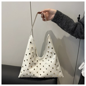 Détail du sac Hobo blanc avec clous métalliques polis et design en forme de triangle