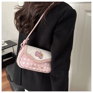 Détail du sac à bandoulière rose et blanc avec broderie pomme et nœud décoratif
