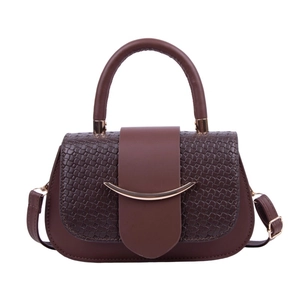 Sac bandoulière marron minimaliste avec texture tressée et détails dorés sur fond blanc