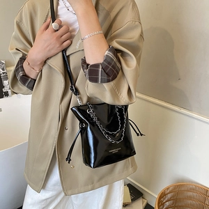 Chic black patent leather bucket bag with silver chain and adjustable shoulder strap