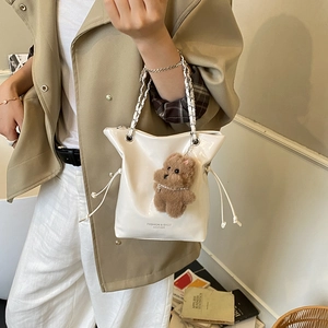 White patent leather bucket bag with chain strap and teddy bear charm for women