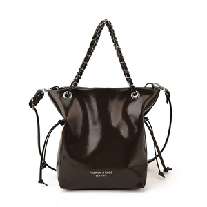 Minimalist glossy oil-wax leather bucket bag with chain handle in a frontal view