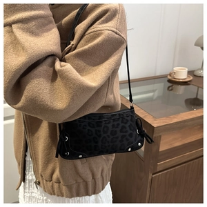 Detail of leopard print shoulder bag with metallic studs and drawstring side accents